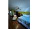 Bright bedroom with wood floors, ceiling fan, and a floral mural accent wall at 5925 Tortosa Pl, Atlanta, GA 30349
