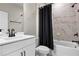 Modern bathroom with a white vanity and a shower-tub combo with marble-look tiling at 2436 Hidden Creek Road, Kennesaw, GA 30152
