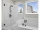 Bright bathroom featuring a glass shower and a soaking tub with a large window at 2436 Hidden Creek Road, Kennesaw, GA 30152
