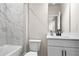 Modern bathroom featuring marble tile walls, white vanity, and sleek black faucet at 2436 Hidden Creek Road, Kennesaw, GA 30152