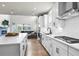 Bright kitchen features white cabinets, stainless steel appliances, and an open layout to the living room at 2436 Hidden Creek Road, Kennesaw, GA 30152