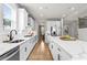 Well-lit kitchen boasts white cabinets, countertops, stainless appliances, and center island with ample counter space at 2436 Hidden Creek Road, Kennesaw, GA 30152