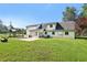 Expansive backyard view features a covered patio, well maintained lawn, and white two story home at 3880 Dial Mill Ne Rd, Conyers, GA 30013