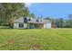 Inviting single-Gathering home with a spacious front yard, stone accents, and a peaceful, wooded view at 3880 Dial Mill Ne Rd, Conyers, GA 30013