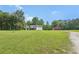 View of a single Gathering home with a large, well-manicured lawn and outbuilding at 3880 Dial Mill Ne Rd, Conyers, GA 30013