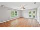 Spacious living room with wood flooring, a ceiling fan, and a window overlooking the backyard at 3880 Dial Mill Ne Rd, Conyers, GA 30013