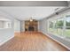 Spacious living room features a stone fireplace, large windows, and wood-look flooring at 3880 Dial Mill Ne Rd, Conyers, GA 30013