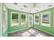 Inviting sunroom with green walls, tile flooring, ceiling fan and multiple windows offering an abundance of light at 3880 Dial Mill Ne Rd, Conyers, GA 30013