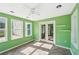 Charming sunroom with green walls, tile floor, ceiling fan, and sliding glass doors leading to the outdoors at 3880 Dial Mill Ne Rd, Conyers, GA 30013