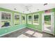 Bright sunroom featuring green walls, a ceiling fan, tile floor, and abundant natural light at 3880 Dial Mill Ne Rd, Conyers, GA 30013