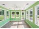 Bright sunroom with green walls, tiled floor, ceiling fan, and lots of windows offering backyard views at 3880 Dial Mill Ne Rd, Conyers, GA 30013