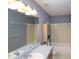 Well-lit bathroom featuring a built-in shelf, bathtub, and a large mirror above the double sink at 5665 Stewart Woods Dr, Douglasville, GA 30135