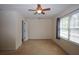 Bright bedroom with a ceiling fan, plush carpet, and a large window overlooking the outdoors at 5665 Stewart Woods Dr, Douglasville, GA 30135