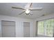 Bright bedroom with a ceiling fan and two closets, offering ample storage space for homeowners at 5665 Stewart Woods Dr, Douglasville, GA 30135