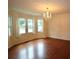 Spacious living room with hardwood floors, a decorative chandelier, and abundant natural light from large windows at 5665 Stewart Woods Dr, Douglasville, GA 30135