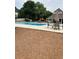 Community pool area with lounge chairs, umbrellas, and clubhouse for relaxation and recreation at 999 Ashebrooke Ne Way, Marietta, GA 30068