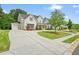 Two-story home boasts an attached garage, circular driveway, beautifully landscaped front yard, and inviting front porch at 107 Owens Mill Place, Canton, GA 30115