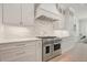 Kitchen with a stainless steel range, hood, custom cabinets, and marble countertops at 107 Owens Mill Place, Canton, GA 30115
