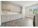 Bright laundry room with gray cabinets, quartz countertop, and a window providing natural light at 107 Owens Mill Place, Canton, GA 30115