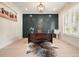 Modern home office featuring dark wood floors, a decorative wall, and ample natural light at 107 Owens Mill Place, Canton, GA 30115
