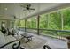 Covered outdoor patio with furniture, ceiling fans, and a view of a lush green forest at 107 Owens Mill Place, Canton, GA 30115