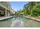 Backyard with a sparkling pool, stone patio, lounge chairs, and privacy at 107 Owens Mill Place, Canton, GA 30115