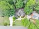 Aerial view of a home surrounded by lush trees, complemented by a meticulously landscaped yard and driveway at 1455 Lockridge Dr, Cumming, GA 30041