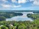 Stunning aerial view of a luxury home surrounded by beautiful trees and serene lake views at 1455 Lockridge Dr, Cumming, GA 30041