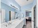 Bathroom with blue walls, double vanity, and large mirror at 1455 Lockridge Dr, Cumming, GA 30041