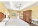 Bedroom with a tray ceiling, hardwood floors, and decorative mirror at 1455 Lockridge Dr, Cumming, GA 30041