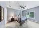 Spacious bedroom features a four-poster bed, a ceiling fan, and a large window with natural light at 1455 Lockridge Dr, Cumming, GA 30041