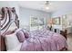 Bedroom with lilac bedspread, carpet, ceiling fan and window overlooking a large yard at 1455 Lockridge Dr, Cumming, GA 30041