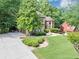 Long driveway leading to a home with mature trees, professional landscaping, and attached garage at 1455 Lockridge Dr, Cumming, GA 30041