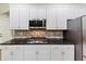 Updated kitchen with stainless steel appliances, granite countertops, and white cabinetry at 1455 Lockridge Dr, Cumming, GA 30041