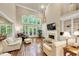 Spacious living room featuring a fireplace, vaulted ceiling, large windows, and hardwood floors at 1455 Lockridge Dr, Cumming, GA 30041