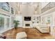 Spacious living room featuring a fireplace, vaulted ceiling, large windows, and hardwood floors at 1455 Lockridge Dr, Cumming, GA 30041