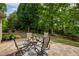 Serene backyard features lush lawn, mature trees, and a patio dining set, creating a peaceful outdoor retreat at 710 Eastbourne Ct, Alpharetta, GA 30005