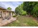 Expansive backyard features a stone patio, lush lawn, mature trees, and beautiful landscaping at 710 Eastbourne Ct, Alpharetta, GA 30005