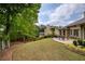 Spacious backyard featuring patio, lush lawn, and mature trees, perfect for outdoor living and entertaining at 710 Eastbourne Ct, Alpharetta, GA 30005