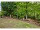 Lush backyard with mature trees offers a tranquil setting, perfect for relaxing and enjoying the natural surroundings at 710 Eastbourne Ct, Alpharetta, GA 30005