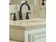 Close-up of a bathroom sink with a black faucet, marble countertop, and white cabinetry at 710 Eastbourne Ct, Alpharetta, GA 30005