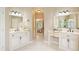Dual vanity bathroom with white cabinetry, marble countertops, decorative mirrors, and tile flooring at 710 Eastbourne Ct, Alpharetta, GA 30005