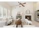 Bright living room featuring a fireplace, ceiling fan, and large windows for ample light at 710 Eastbourne Ct, Alpharetta, GA 30005
