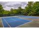Two tennis courts at the Westbury community are surrounded by mature trees and include benches for players at 710 Eastbourne Ct, Alpharetta, GA 30005