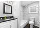 Updated bathroom with a tub shower, modern fixtures, granite countertop, and elegant mirror at 969 Oak Sw St, Atlanta, GA 30310