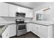Bright kitchen featuring white cabinetry, granite countertops, and stainless steel appliances at 969 Oak Sw St, Atlanta, GA 30310