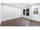 Bright room featuring dark wood floors, a large window, and a white door at 969 Oak Sw St, Atlanta, GA 30310