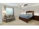 Cozy bedroom featuring a bed, a floral loveseat, a ceiling fan, and a large window at 1501 Jamerson Landing, Marietta, GA 30066