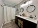 Well-lit bathroom featuring a double vanity, modern mirrors, and shower with curtain at 1782 Telfair Chase Way, Lawrenceville, GA 30043