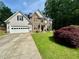 Charming two-story home featuring stone and shingle siding, well-manicured lawn, and an attached two-car garage at 1782 Telfair Chase Way, Lawrenceville, GA 30043
